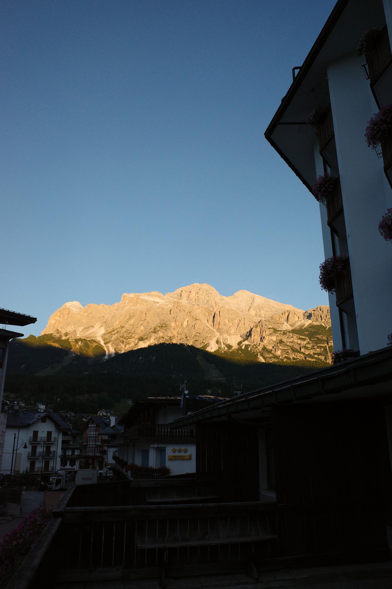 Evening alpenglow on a Dolomite range seen from a balcony above an Italian mountain town