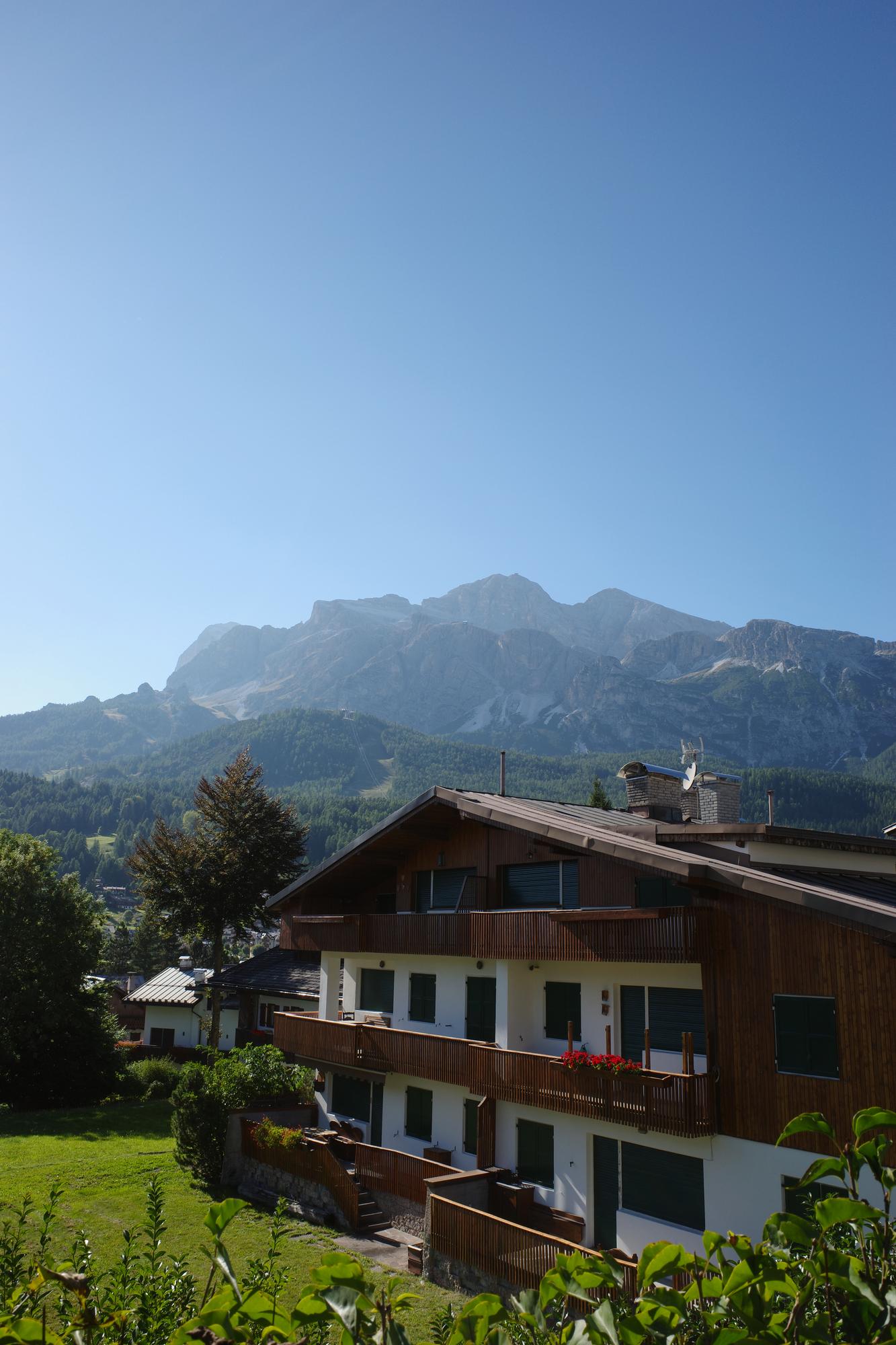 A traditional wooden alpine chalet with limestone peaks behind it