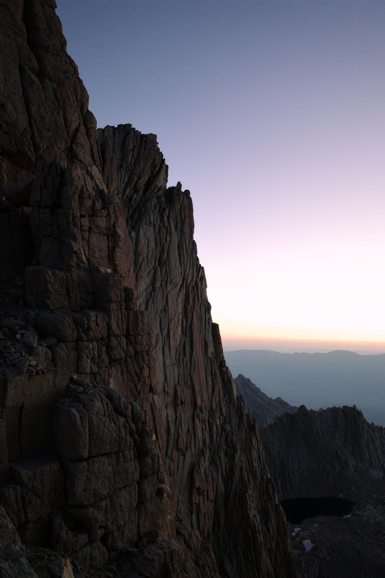 Alpenglow light on a steep granite face at dawn in the Sierra Nevada